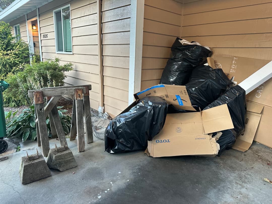 front yard full of cardboard wood and bags full of trash ready to be removed